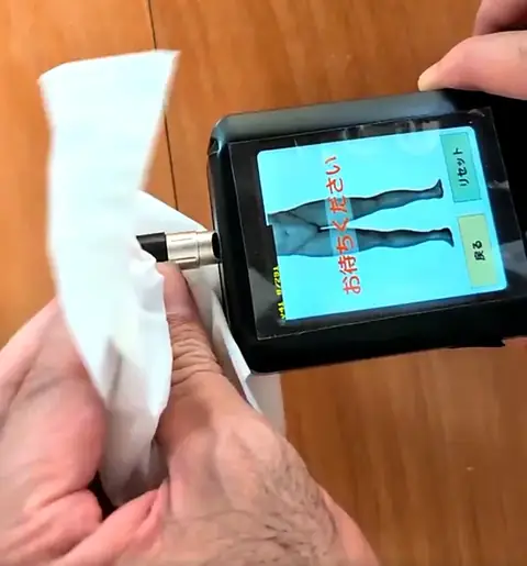 ティッシュでセンサーの先端部分を拭き取る様子